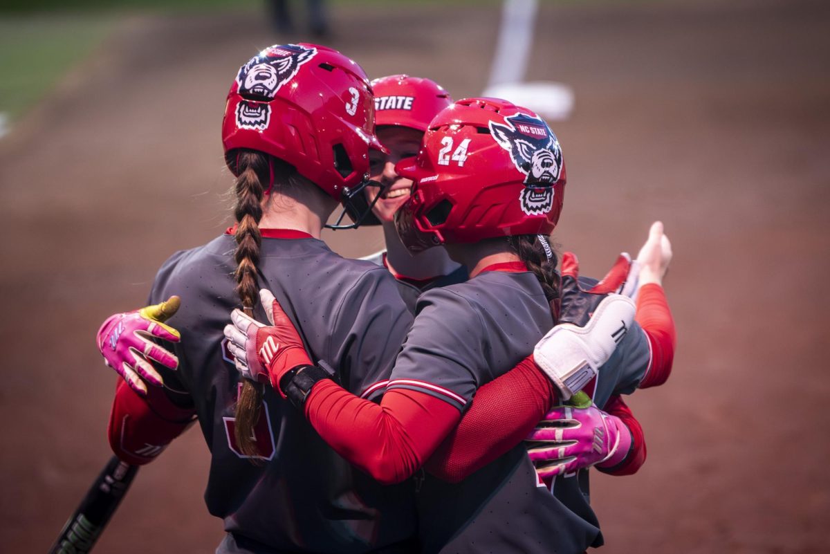 Freshman infielder Lily Livingston (middle) celebrates with teammates after hitting a home run during the game against Queens in Dail Softball Stadium on Tuesday, Feb. 17, 2026. The Wolfpack defeated the Royals 10-0 in five innings.
