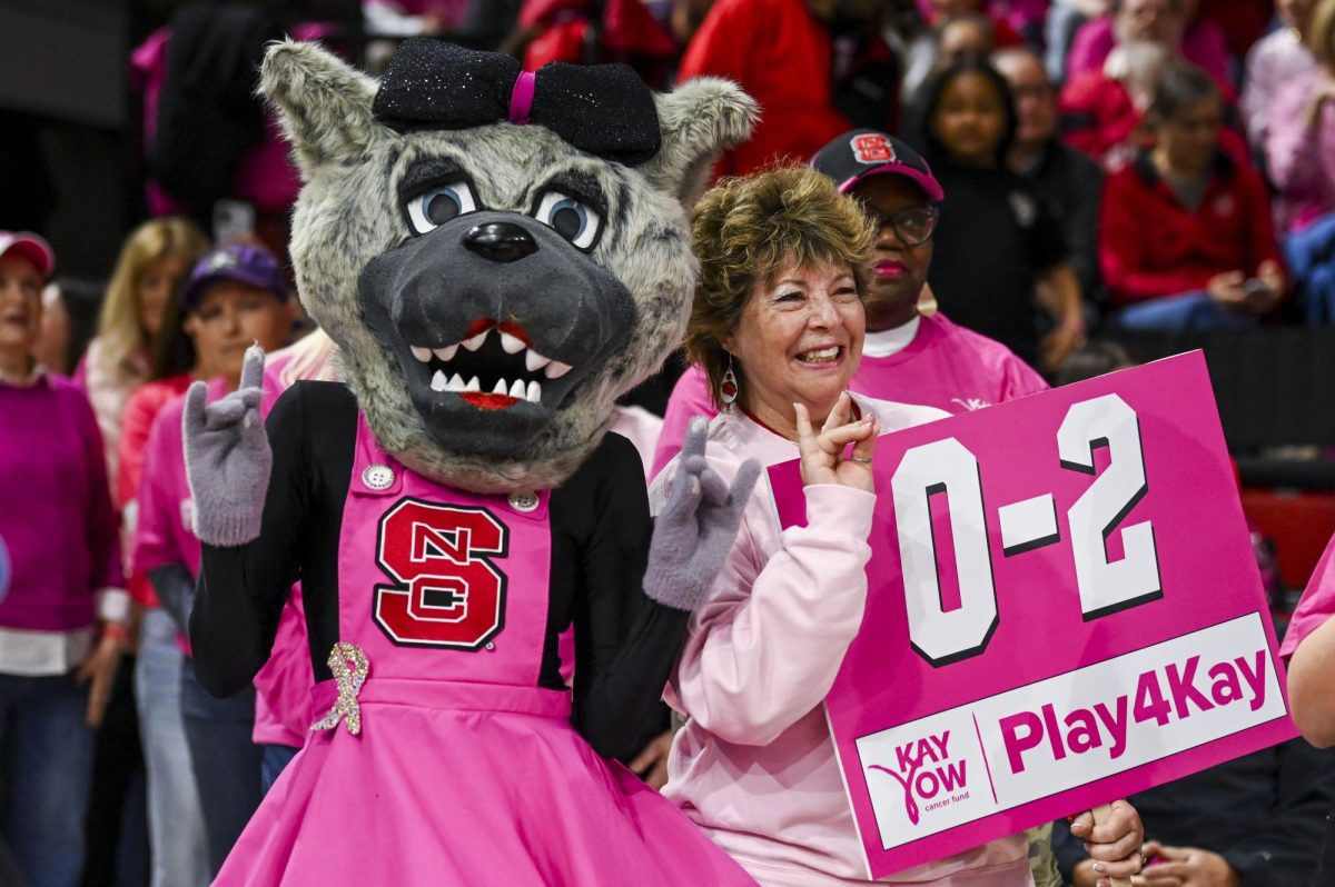 Mrs. Wuf and Jennifer Day smile during the Play4Kay game against UNC-Chapel Hill at Reynolds Coliseum on Monday, Feb. 2, 2026. The Play4Kay game is used to raise money for the Kay Yow Cancer Fund and to celebrate cancer survivors. The Tar Heels defeated the Wolfpack 61-59. 