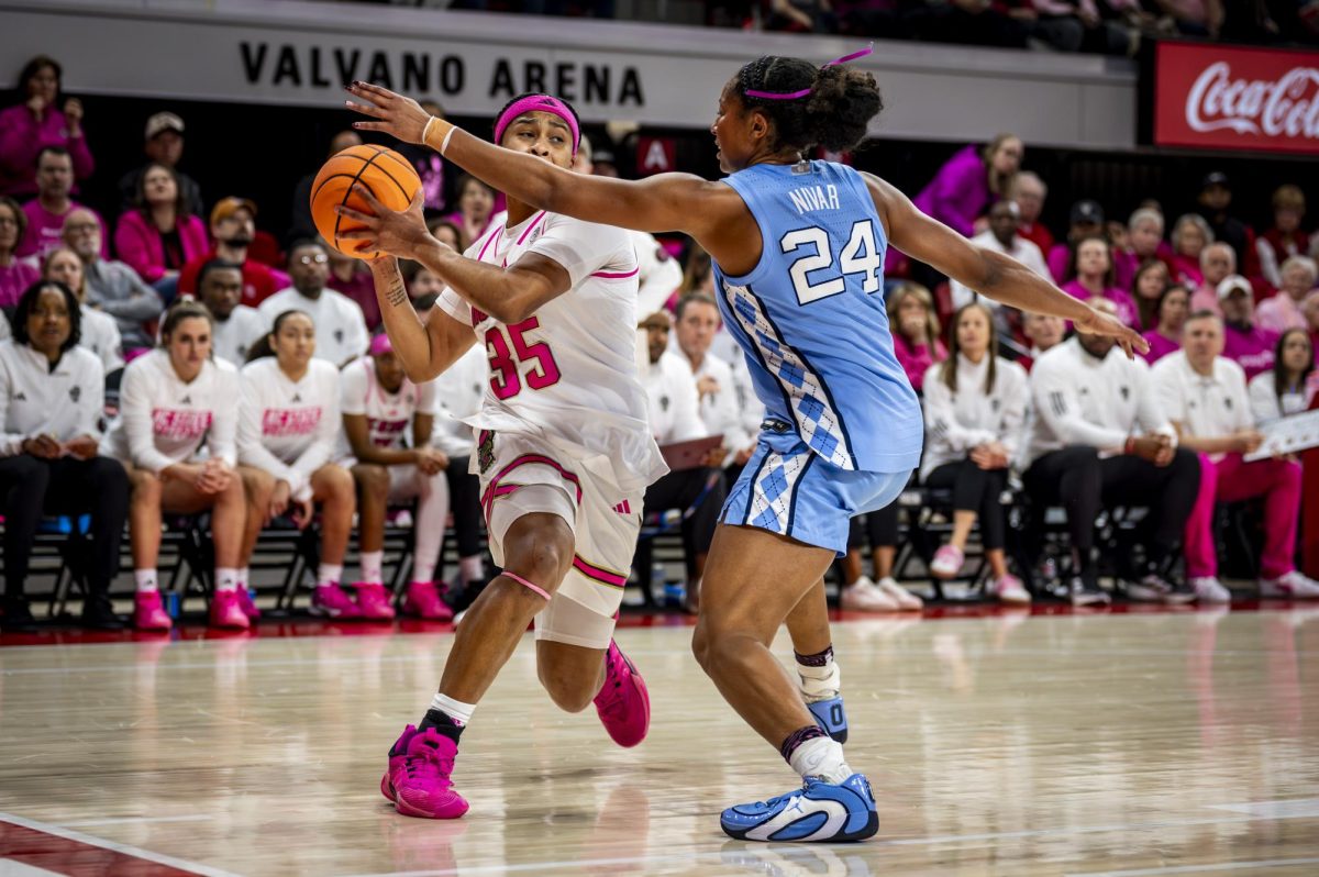 NC State junior guard Zoe Brooks (35) is defended by UNC senior guard Indya Nivar (24) during the Play4Kay game in Reynolds Coliseum on Monday, Feb. 2, 2026. The Tar Heels defeated the Wolfpack 61-59.