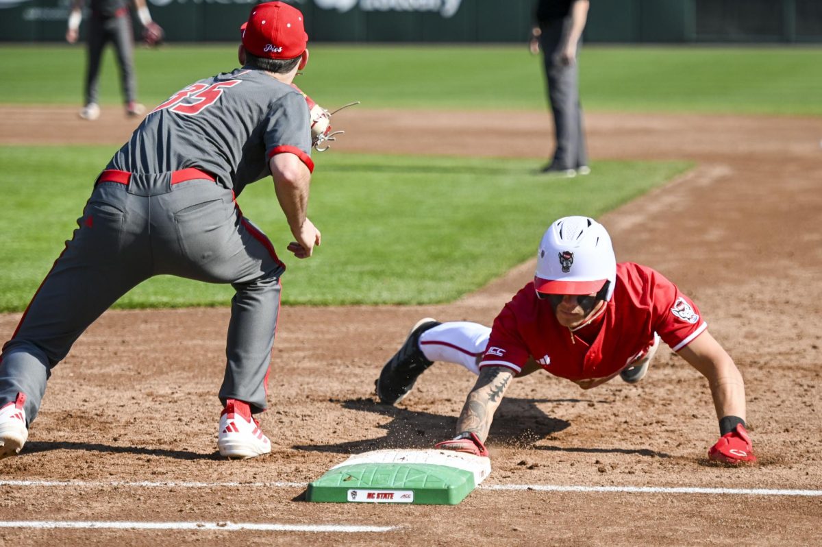 Sophomore outfielder Ty Head dives back into first during the game against Sacred Heart in Doak Field in Dail Park on Sunday, March 1, 2026. The Wolfpack defeated the Pioneers 13-0.