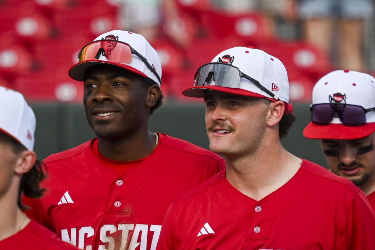 Junior outfielder Sherman Johnson and junior outfielder Devin Mitchell smile as they walk back to the dugout after the game against Sacred Heart in Doak Field in Dail Park on Sunday, March 1, 2026. The Wolfpack defeated the Pioneers 13-0.