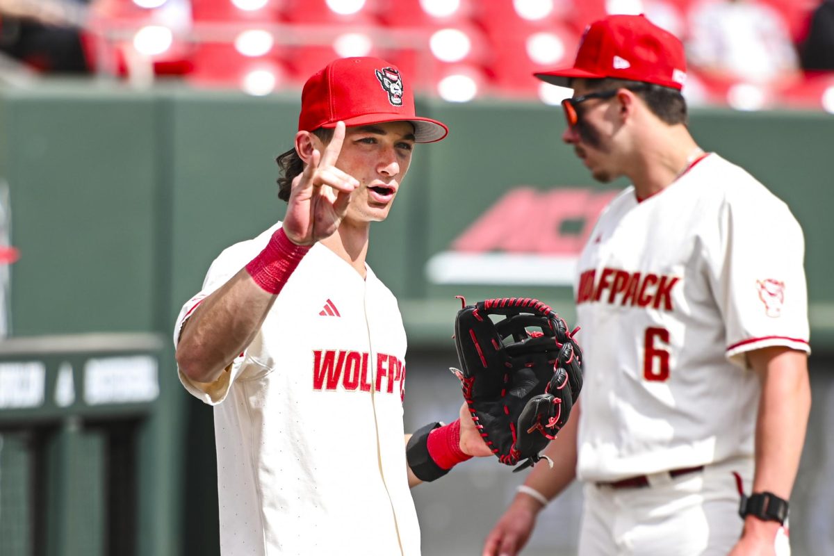 Freshman outfielder Rett Johnson throws a "wolfie" sign during the game against Boston College at Doak Field at Dail Park on Sunday, March 15, 2026. NC State beat Boston College 5-1.