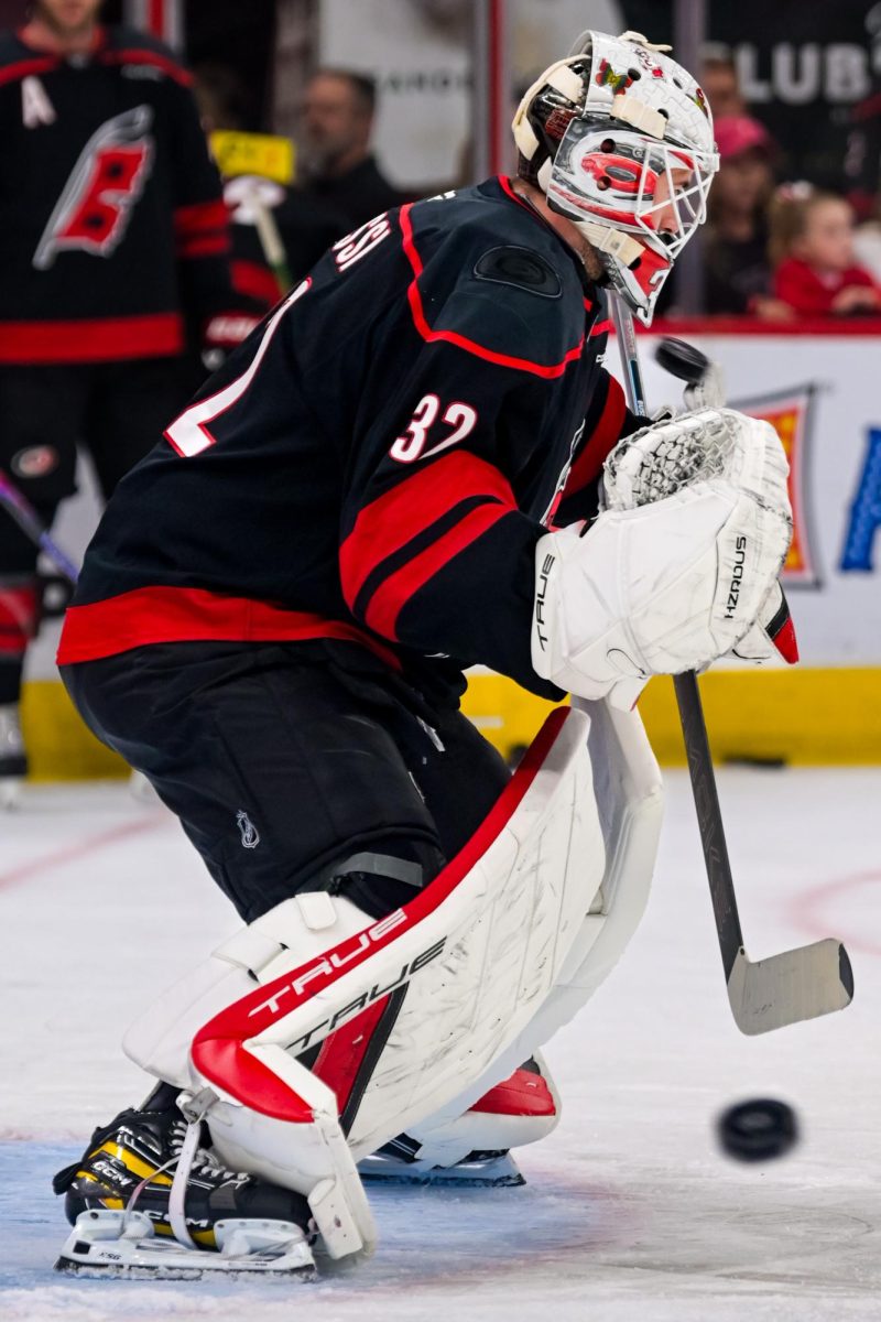 Goalie Brandon Bussi surrounded by flying pucks during warm ups before the game versus the New Jersey Devils at the Lenovo Center on Saturday, March 28, 2026. The Canes beat the Devils 5-2.