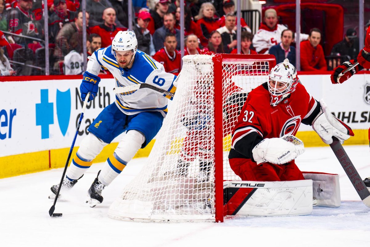 Blues defenseman Philip Broberg skates around Hurricanes goalie Brandon Bussi during the game in the Lenovo Center on Thursday, March 12, 2026. The Blues Defeated the Hurricanes 3-1.