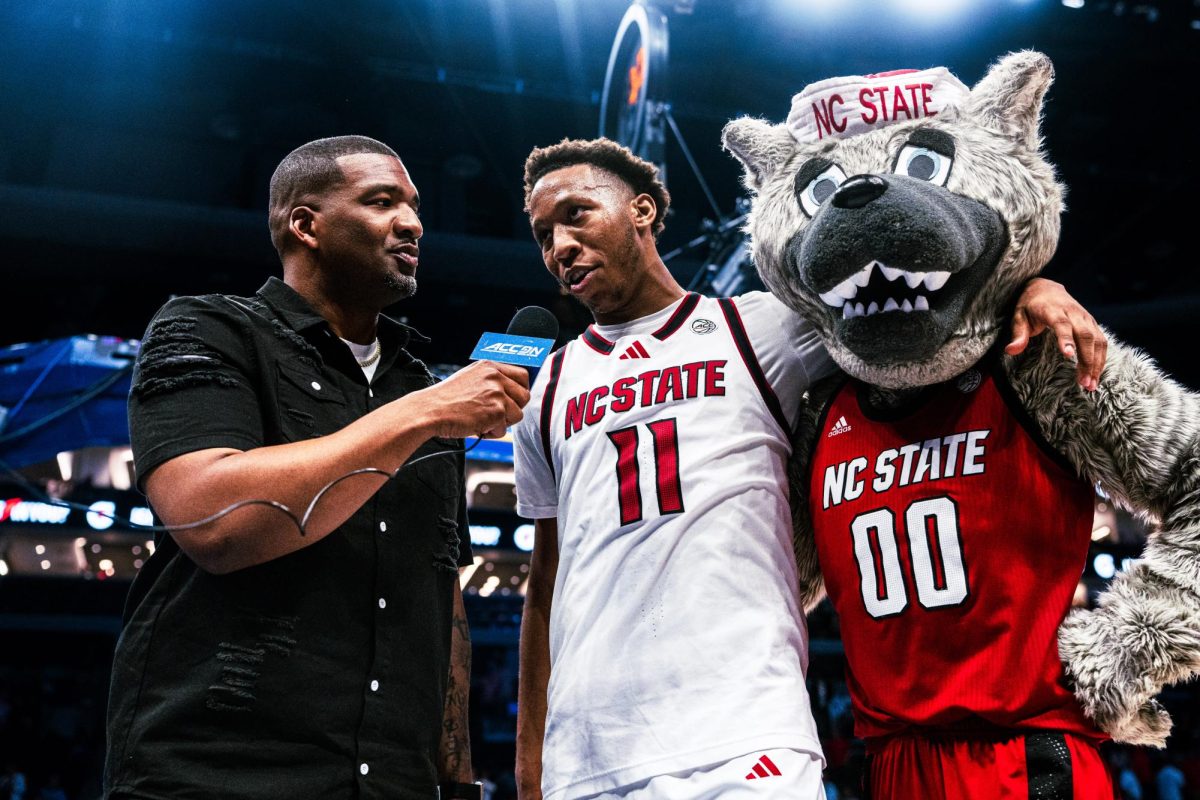 Senior guard Quadir Copeland stands with Mr.Wuf while being interviewed after the game against Pitt in the Spectrum Center on Wednesday, March 11, 2026. Copeland led in scoring with 24 points. The Wolfpack defeated the Panthers 98-88.