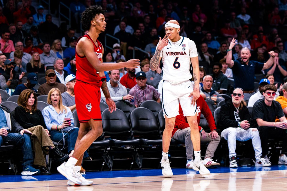 Virginia graduate guard Jacari White celebrates in front of NC State guard Paul McNeil Jr after scoring a three-point shot during the game against Virginia in the Spectrum Center on Thursday, March 12, 2026. Williams scored seven points. NC State fell to Virginia 81-74.
