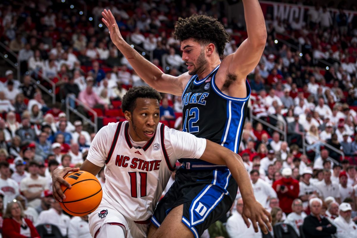 NC State senior guard Quadir Copeland (11) is cut off by Duke freshman forward Cameron Boozer (12) on a drive to the basket during the game in the Lenovo Center on Monday, March 2, 2026. The Blue Devils defeated the Wolfpack 93-64.