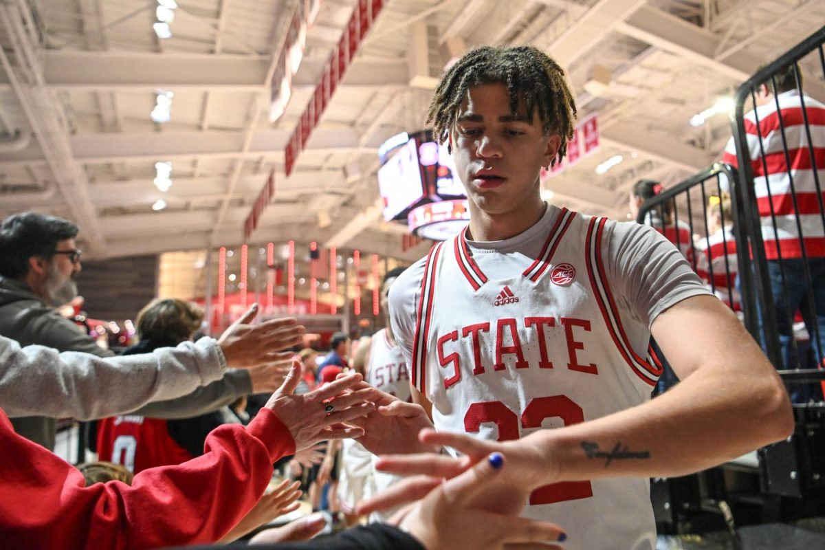 Sophomore guard Jordan Snell high-fives fans while exiting the court after the annual Heritage Game against Maryland Eastern Shore in Reynolds Coliseum on Wednesday, Dec. 6, 2023.  NC State beat Maryland Eastern Shore 93-61.