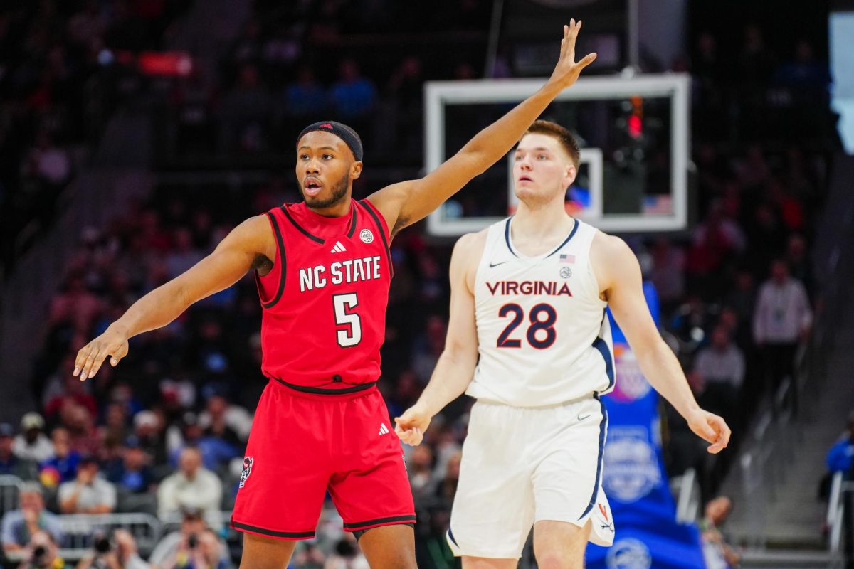 Senior guard Tre Holloman guards Virginia player Thijs De Ridder during the game against Virginia in the Spectrum Center on Thursday, March 12, 2026. NC State fell to Virginia 81-74.