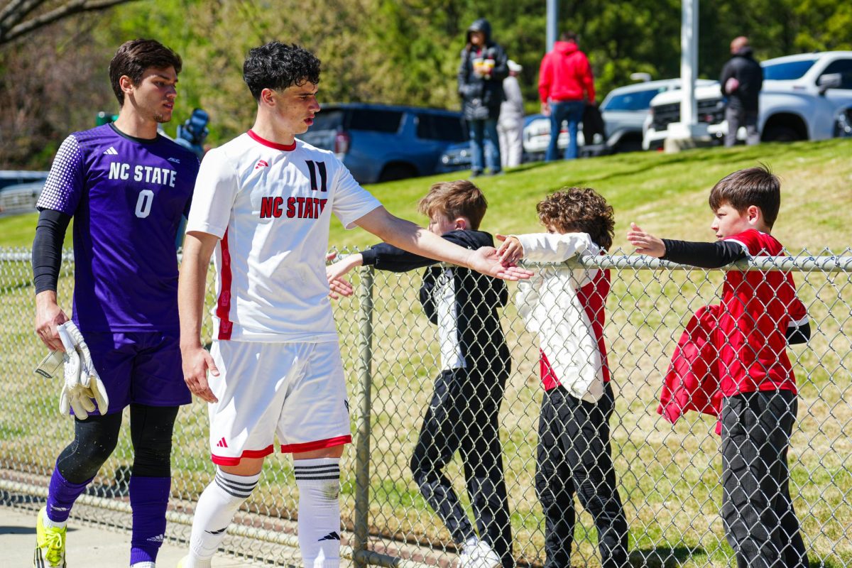 Junior goalkeeper Mattheus Rhormens and junior forward Frankie DeFrancesco high-five fans after the match against Virginia Tech at WakeMed Soccer Park on Saturday, March 28, 2026. NC State fell to Virginia Tech 1-0.