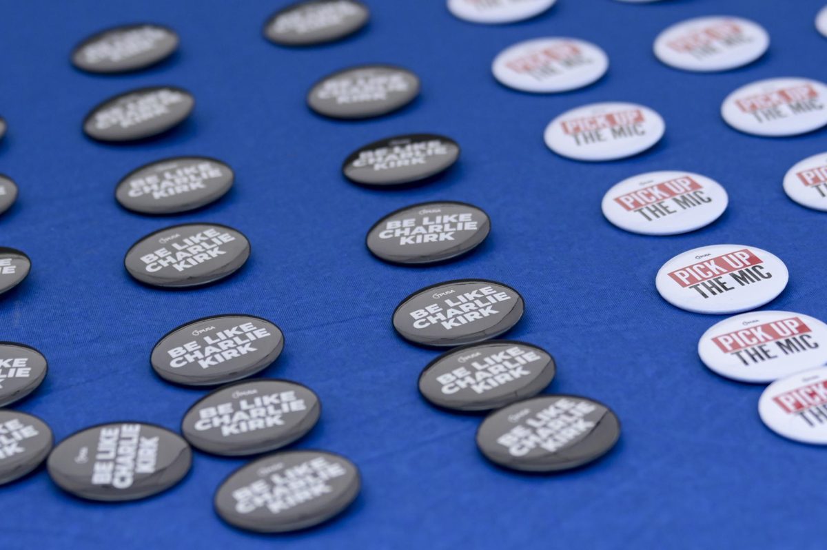 Buttons saying "Be Like Charlie Kirk" during Turning Point Action's "Prove Me Wrong" debate on Harris Field on Monday, March 30, 2026. 