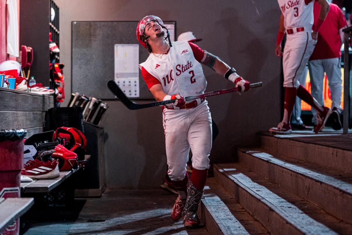 Sophomore infielder Mikey Ryan swings a hockey stick in the dugout after hitting during the game against Duke at Doak Field at Dail Park on Friday, April 10, 2026. The Wolfpack beat The Blue Devils 10-4.