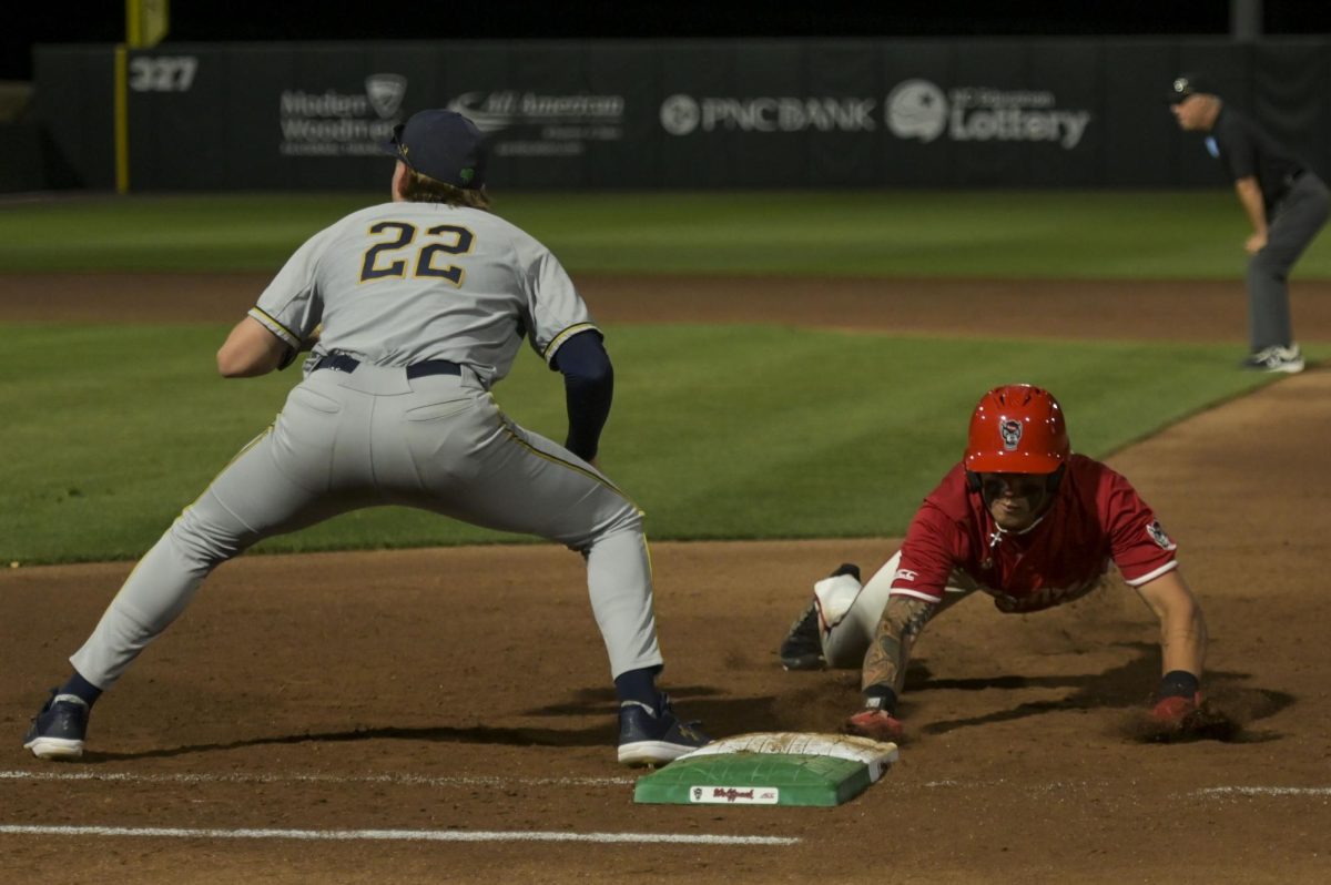 Sophomore outfielder Ty Head dives back into first during the game against Notre Dame at Doak Field at Dail Park on Thursday, April 4, 2026. NC State defeated Notre Dame 7-3.
