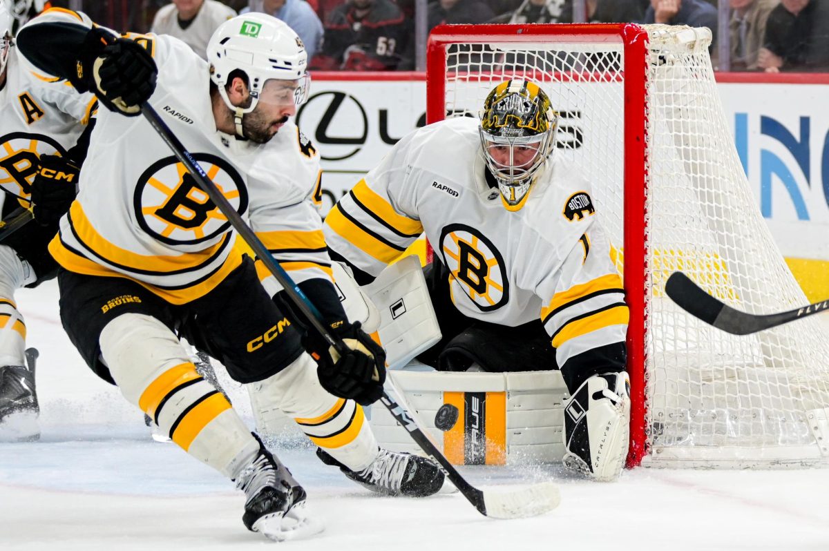 Boston goalie Jeremy Swayman keeps his eye on the puck as defenseman Jordan Harris rushes to the net during the game versus the Carolina Hurricanes at the Lenovo Center on Tuesday, April 7, 2026. The Canes defeated the Bruins in OT 6-5.