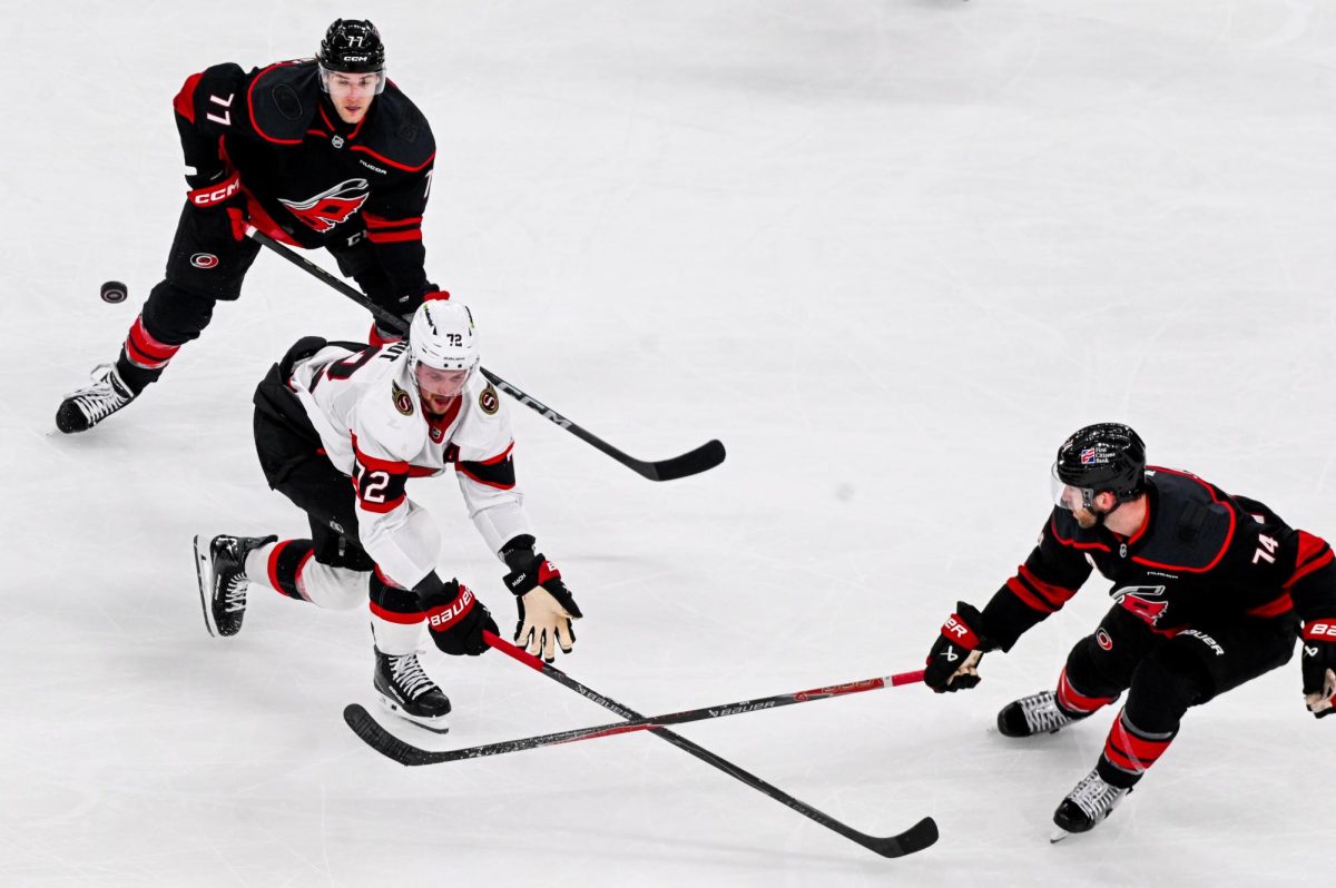 Defenseman Jaccob Slavin and left wing Mark Jankowski double down against Senators defenseman Thomas Chabot during Game One of the Eastern Conference Playoffs against the Ottawa Senators at the Lenovo Center on Saturday, April. 18, 2026.  The Hurricanes defeated the Senators 2-0.