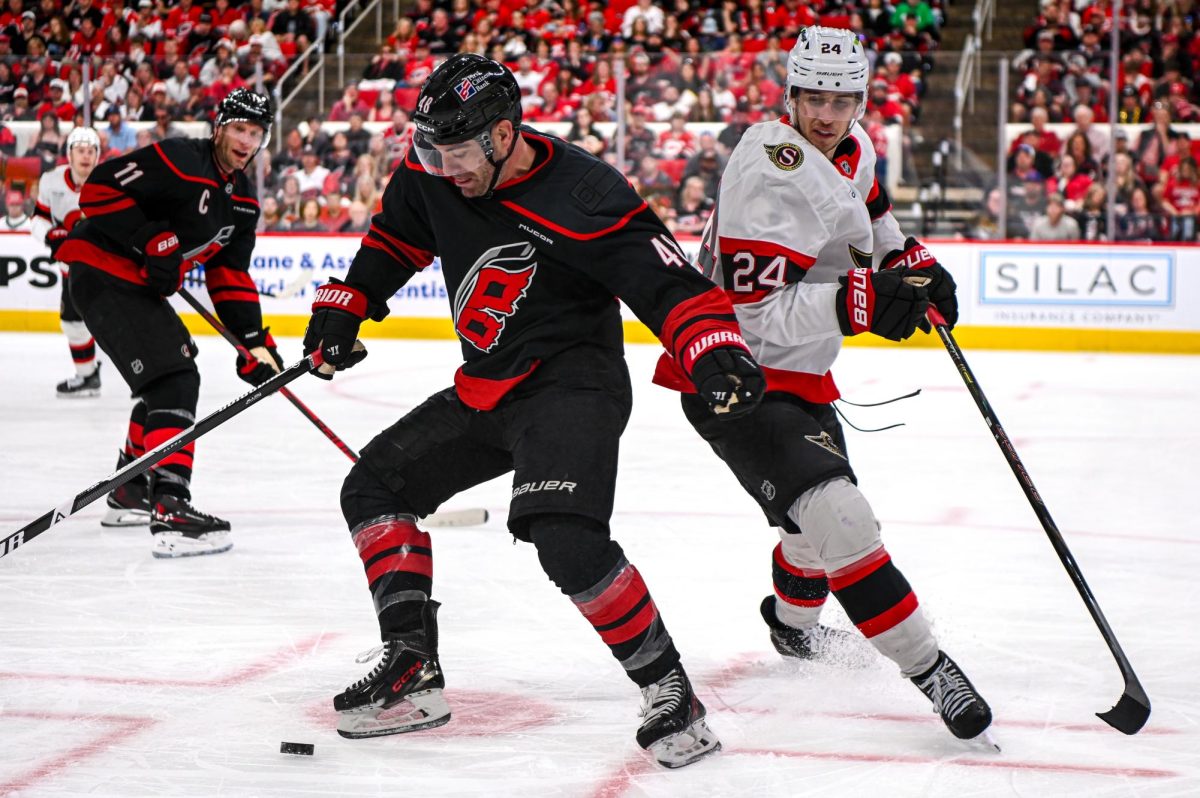Canes left wing Jordan Martinook defends the puck from Senators center Dylan Cozens during Game One of the Eastern Conference Playoffs at the Lenovo Center on Saturday, April. 18, 2026. The Hurricanes defeated the Senators 2-0.