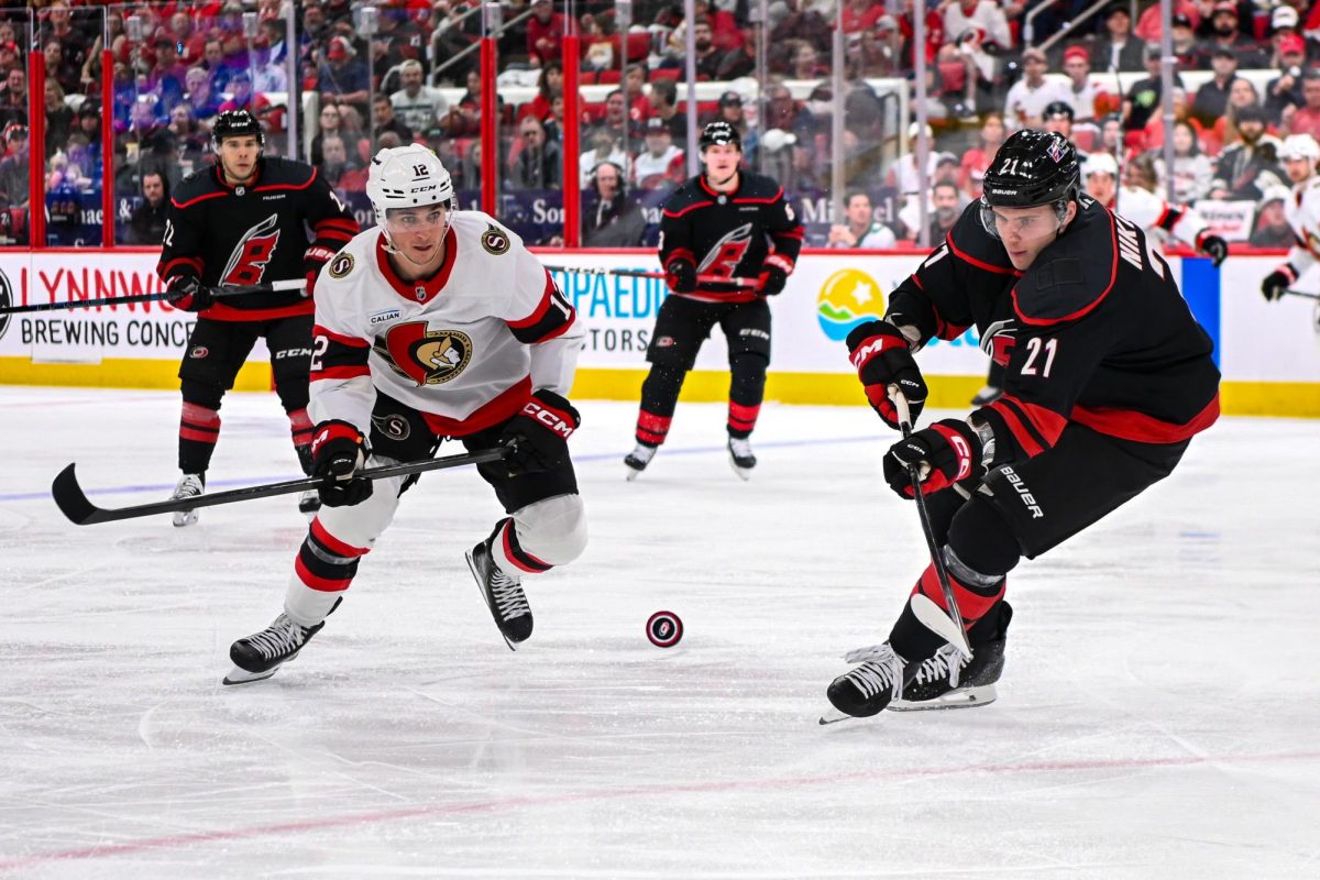 Canes defenseman Alexander Nikishin battles Senators center Shane Pinto for the puck in Game One of the Eastern Conference Playoffs at the Lenovo Center on Saturday, April. 18, 2026.  The Hurricanes defeated the Senators 2-0.