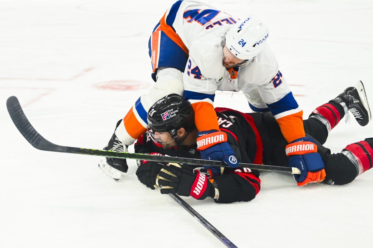 Left wing William Carrier is pinned by an opponent during the game versus the New York Islanders at the Lenovo Center on Saturday, April 4, 2026. The Hurricanes beat the Islanders 4-3.