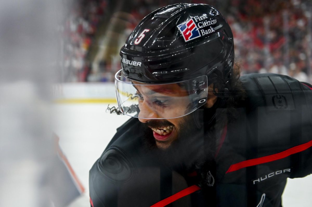 Defenseman Jalen Chatfield battles an opponent for the puck  during the game versus the New York Islanders at the Lenovo Center on Saturday, April 4, 2026. The Hurricanes beat the Islanders 4-3.