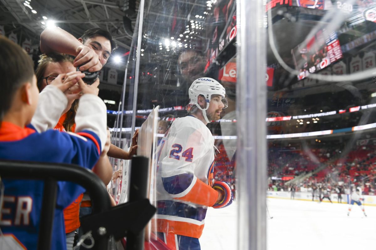 An Islanders fan hands off a puck during warm-ups before the game versus the New York Islanders at the Lenovo Center on Saturday, April 4, 2026. The Hurricanes beat the Islanders 4-3.
