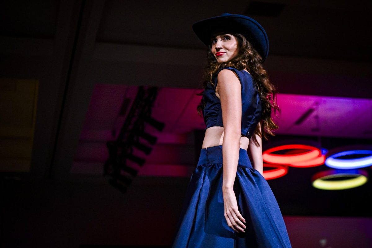 A model smirks at the judges during the Emerging Designers Runway Show and Textile Showcase at Talley State Ballroom on Saturday, April 25, 2026. This model is wearing a piece from Norah Philbin's, a fourth-year studying fashion and textile design, collection Grit.