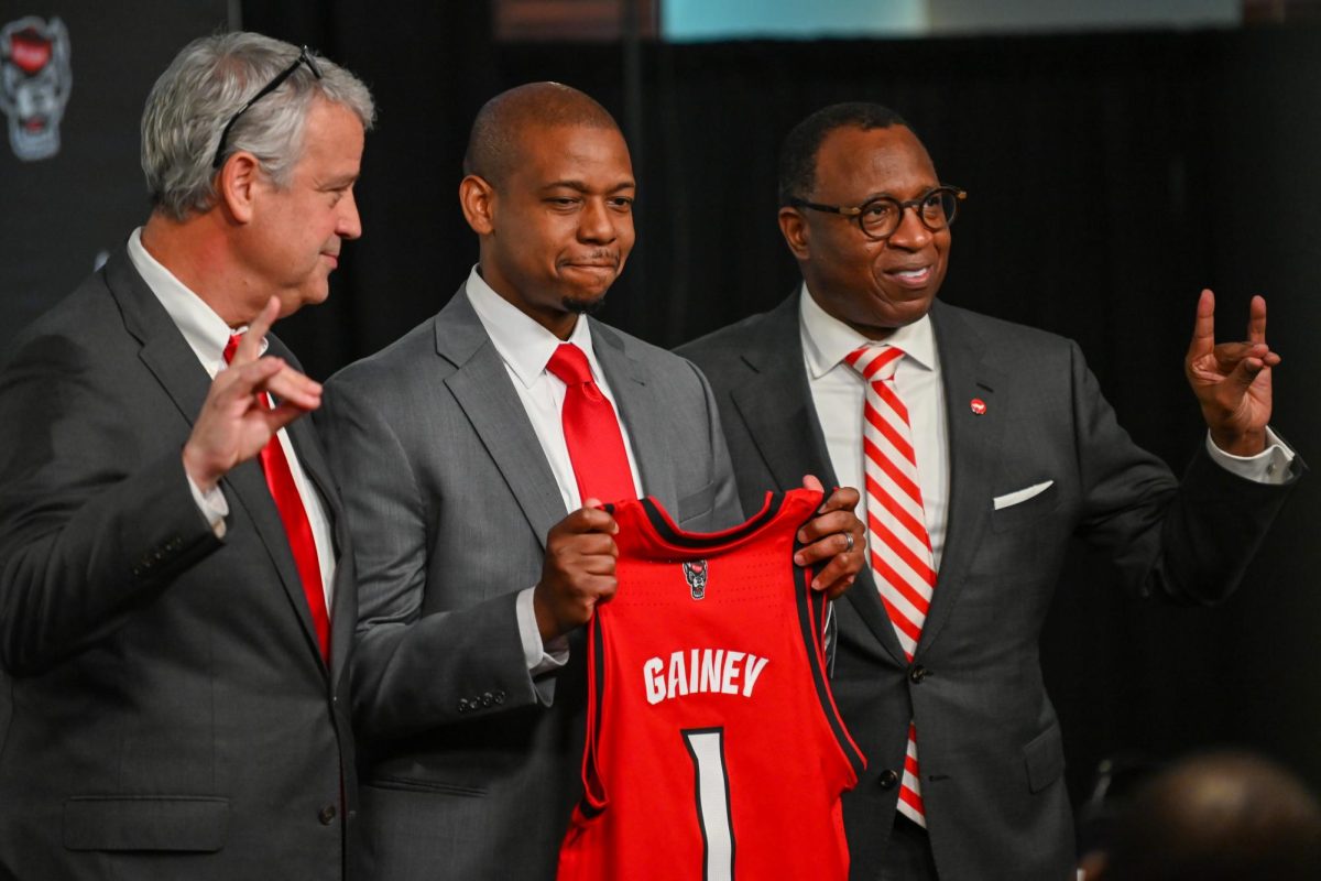 Boo Corrigan, NC State's athletic director, Justin Gainey, NC State men's basketball head coach, and Chancellor Kevin Howell stand Infront of the media during Justin Gainey's introduction press conference at The Lenovo Center on Wednesday April 1, 2026. The event was held for new NC State head coach Justin Gainey and hosted by NC State athletics.