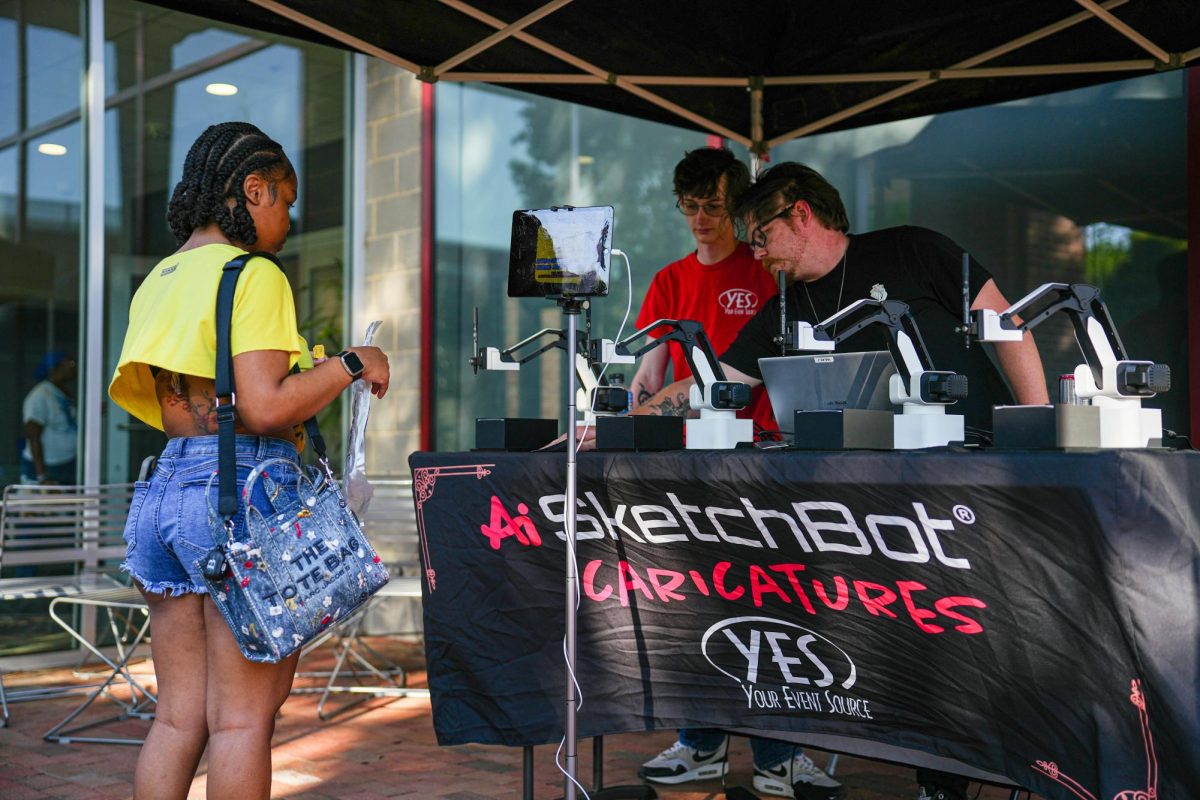 Mckenna Branch, a first-year studying middle grades education, interacts at a booth during the Pan-Afrikan Cookout at Harris Field on Thursday, April 16, 2026. The University Activities Board hosted the event in collaboration with the Black Students Board at N.C. State.