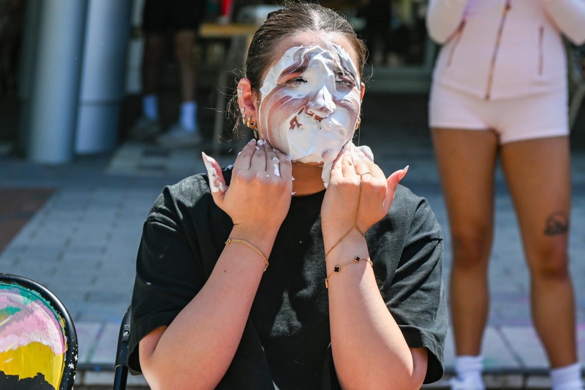 Farah Honiene, a fourth-year student studying business marketing, wipes shaving cream off her face during the Pie BSB Eboard event at Stafford Commons on Tuesday, April. 17, 2026. The pie the Black Student Board Eboard event is part of Pan-African Week, a weeklong celebration of Pan-Africanism that promotes unity among students through fun activities designed for the black community.