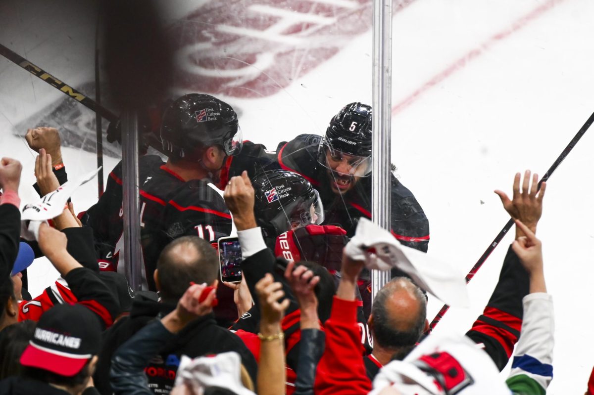 Defenseman Jalen Chatfield celebrates with centers Jordan Staal and Sebastian Aho after a goal scored by Aho during the round one playoff game versus the Ottawa Senators at the Lenovo Center on Monday, April 20, 2026. Aho scored one goal for the Hurricanes. The Hurricanes beat the Senators 3-2 in double overtime.