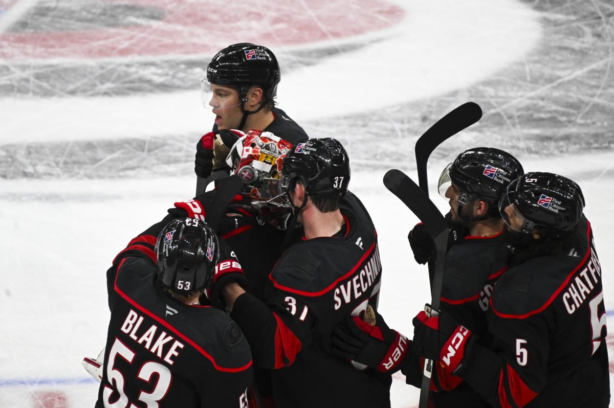 Right wingers Jackson Blake and Andrei Svechnikov hug goalie Frederik Andersen after the round one playoff game versus the Ottawa Senators at the Lenovo Center on Monday, April 20, 2026. The Hurricanes beat the Senators 3-2 in double overtime.