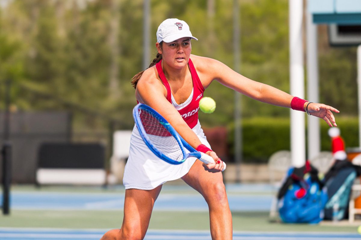 Sophomore Mia Slama lunges down to hit the ball during warm ups before the match against Duke at Cary Tennis Park on Wednesday, April 8, 2026. Slama lost her singles match 5-7,1-6. The Wolfpack fell to the Blue Devils 3-4.