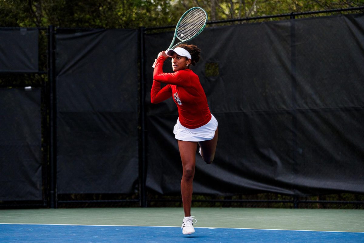 Freshman Victoria Osuigwe follows through with her swing after hitting the ball during the match against Duke at Cary Tennis Park on Wednesday, April 8, 2026. Osuigwe won her singles match 6-3,6-3. The Wolfpack fell to the Blue Devils 3-4.