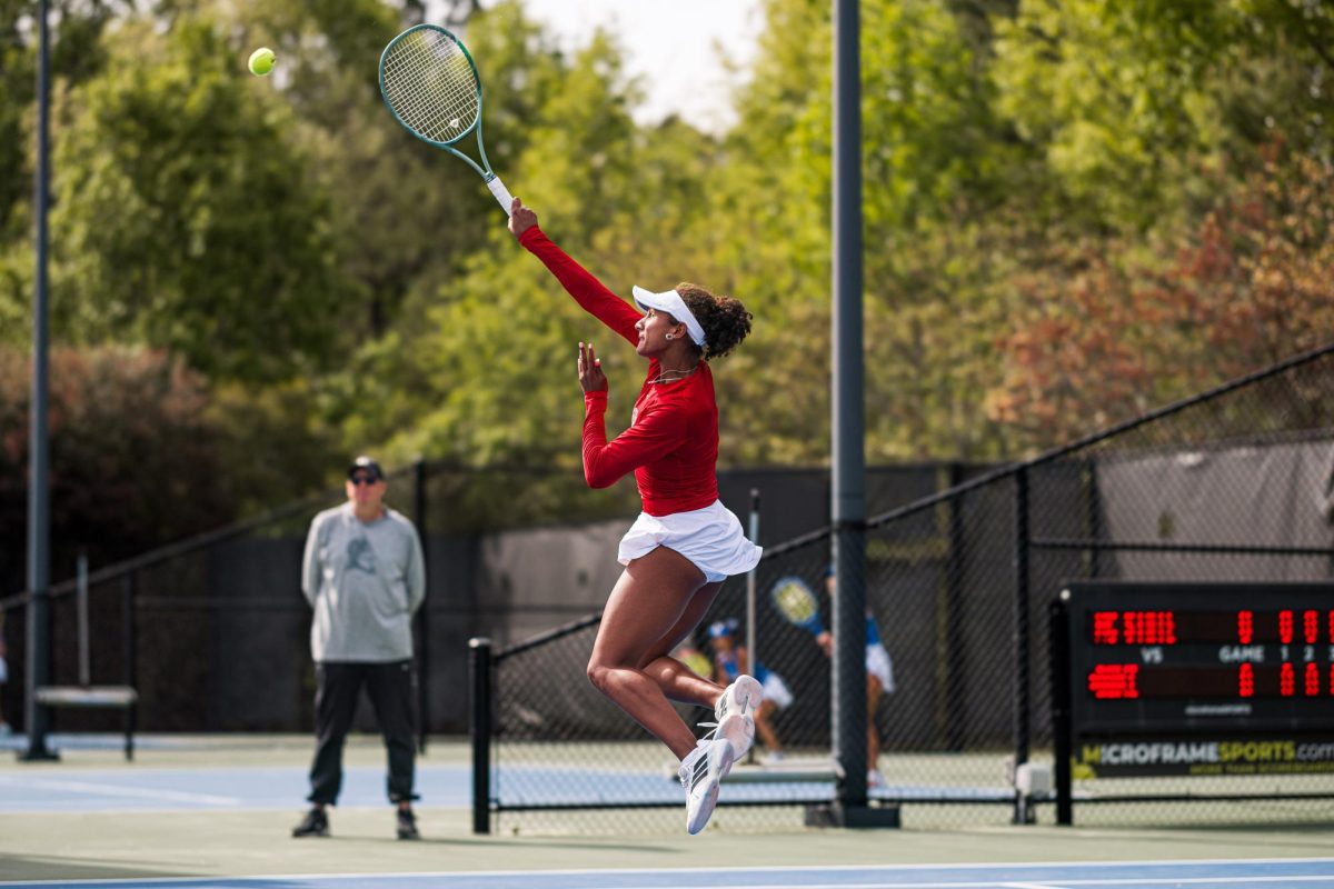 Freshman Victoria Osuigwe jumps into the air to hit the ball during the match against Duke at Cary Tennis Park on Wednesday, April 8, 2026. Osuigwe won her singles match 6-3,6-3. The Wolfpack fell to the Blue Devils 3-4.