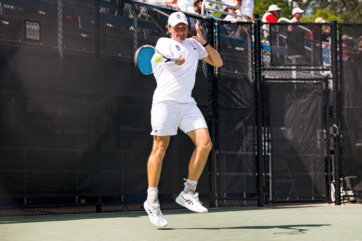 Senior Martin Borisiouk lunges over to hit the ball during his singles match against Florida State in the second round of the ACC Men's Tennis Championship at Cary Tennis Park on Thursday, April 16, 2026. Borisiouk won his singles match 4-6,6-3,6-4. The Wolfpack lost to the Seminoles 3-4.