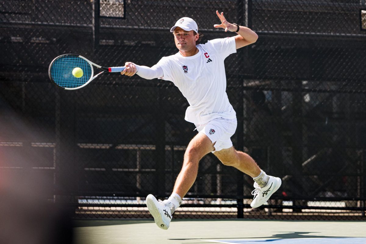 Senior Martin Borisiouk leaps to hit the ball during his singles match against Florida State in the second round of the ACC Men's Tennis Championship at Cary Tennis Park on Thursday, April 16, 2026. Borisiouk won his singles match 4-6,6-3,6-4. The Wolfpack lost to the Seminoles 3-4.