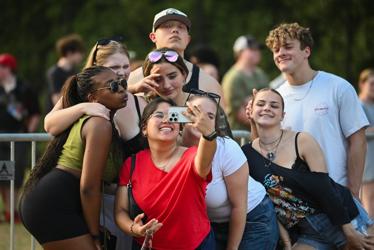 Students gather for a selfie before the Wolfstock concert on Miller Fields on Saturday, April 18, 2026. Wolfstock is NC State's spring concert which includes activities, food, and a concert to close the night. 