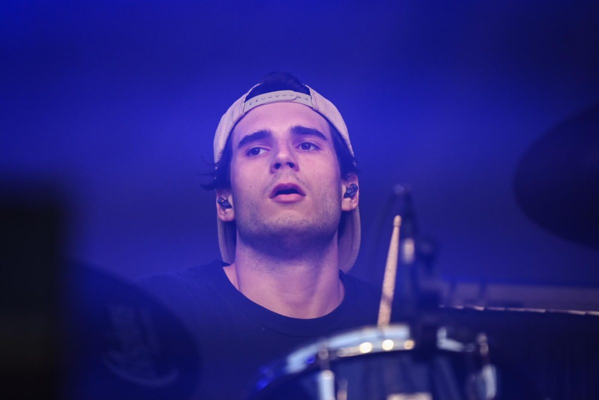 Odd 39 drummer Anthony Vocaturo, a third year in the College of Natural Resources,  eyes the crowd during the Wolfstock concert on Miller Fields on Saturday, April 18, 2026. Odd 39 opened for the Wolfstock concert, which also featured K-CAMP and Yung Gravy. 
