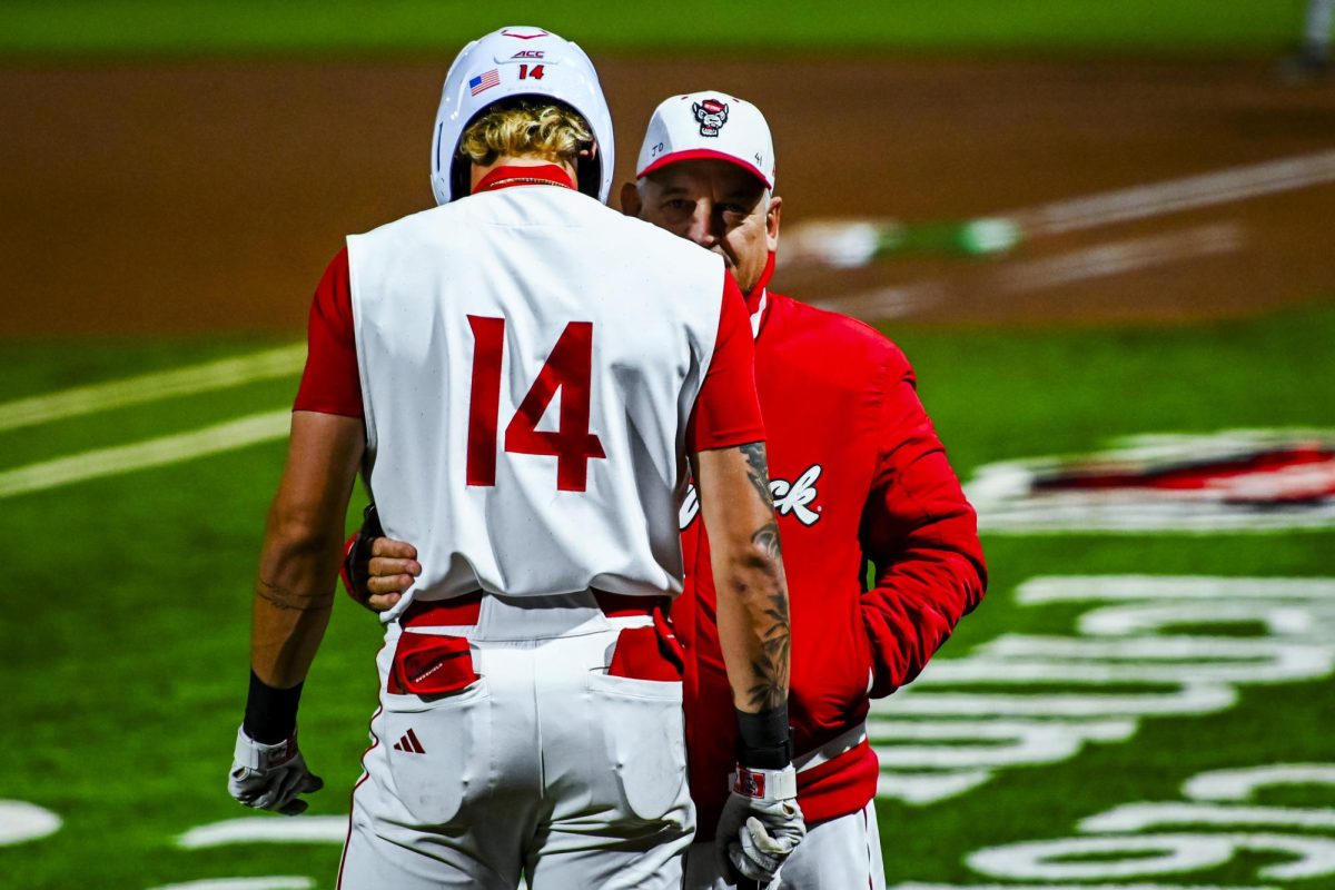 Head coach Elliott Avent speaks with sophomore outfielder Ty Head outside the batter's box during the game against Miami in Doak Field at Dail Park on Saturday, May 2, 2026. The Wolfpack defeated the Hurricanes 12-7.