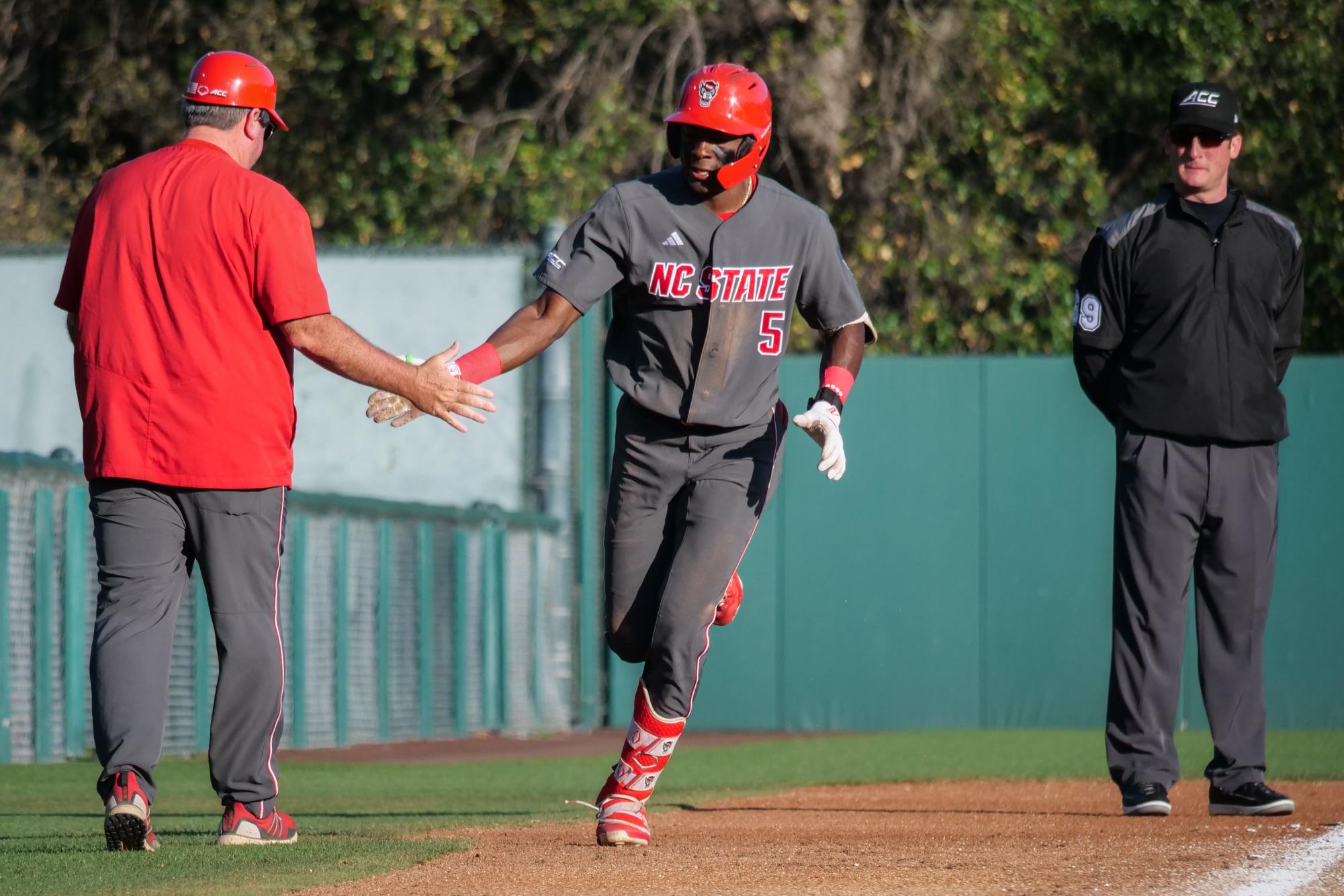 Junior infielder Sherman Johnson high-fives third base coach Christ Hart as he rounds the bases after a home run during the game against Stanford at Klein Field at Sunken Diamond on Friday, May 8, 2026. Johnson was 3-for-3 with three RBIs. The Wolfpack fell to the Cardinal 6-5. 