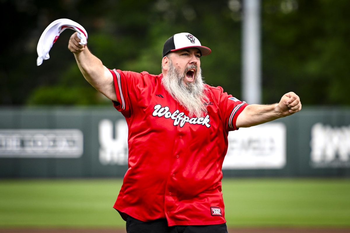 Wolfpack club member Greg Haas cheers after throwing the ceremonial first pitch during the first game of the doubleheader against Miami in Doak Field at Dail Park on Friday, May 1, 2026. The Wolfpack fell to the Hurricanes 12-9.