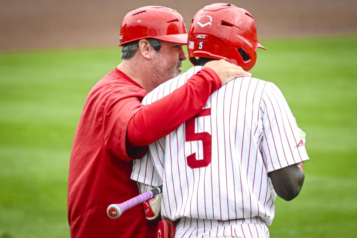 Associate head coach Chris Hart speaks to junior infielder Sherman Johnson in the batter's box during the first game of the doubleheader against Miami in Doak Field at Dail Park on Friday, May 1, 2026. The Wolfpack fell to the Hurricanes 12-9.