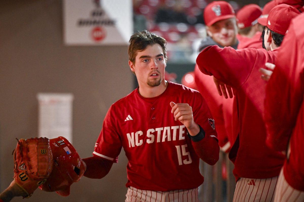 Redshirt-junior catcher Drew Lanphere high-fives his teammates in the dugout after running through home during the second game of the doubleheader against Miami in Doak Field at Dail Park on Friday, May 1, 2026. The Wolfpack defeated the Hurricanes 13-6.