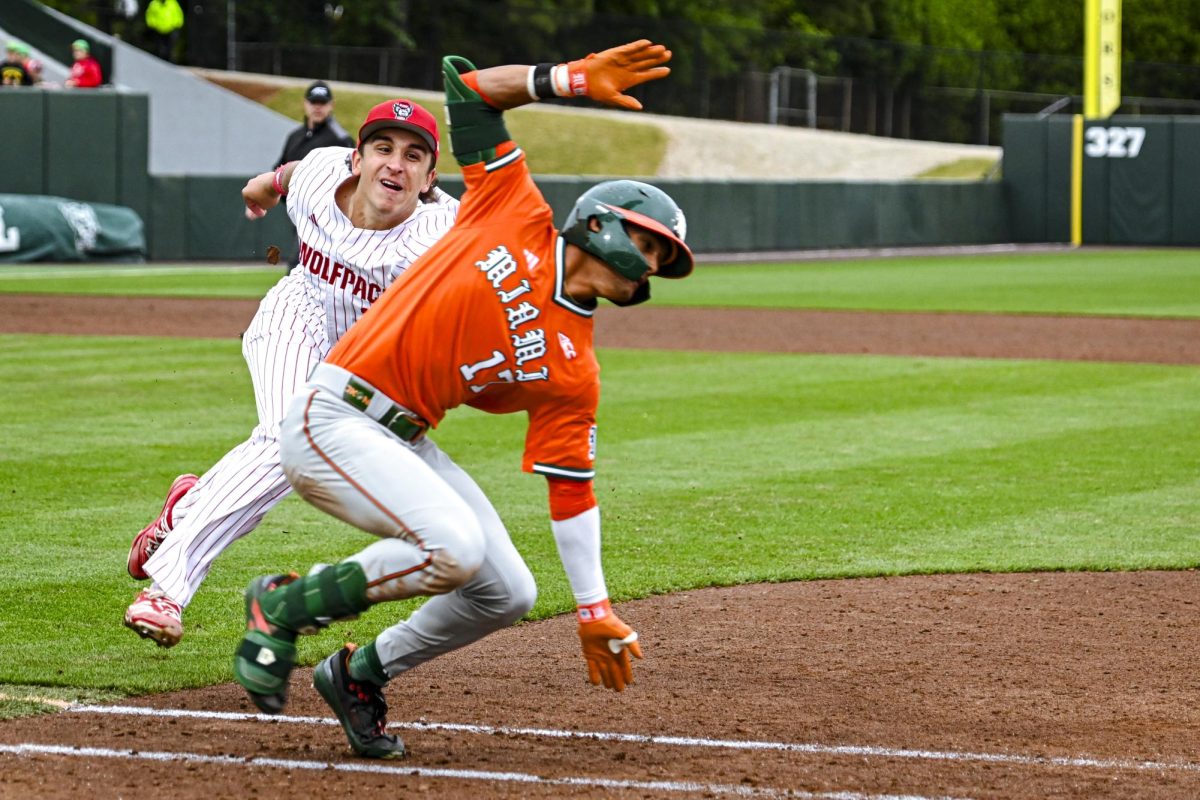 Junior infielder Chris McHugh leaps to tag a runner during the first game of the doubleheader against Miami in Doak Field at Dail Park on Friday, May 1, 2026. The Wolfpack fell to the Hurricanes 12-9.