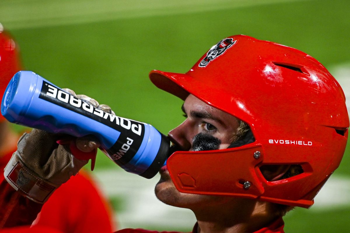 Freshman infielder Christian Serrano hydrates in the dugout during the second game of the doubleheader against Miami in Doak Field at Dail Park on Friday, May 1, 2026. The Wolfpack defeated the Hurricanes 13-6.
