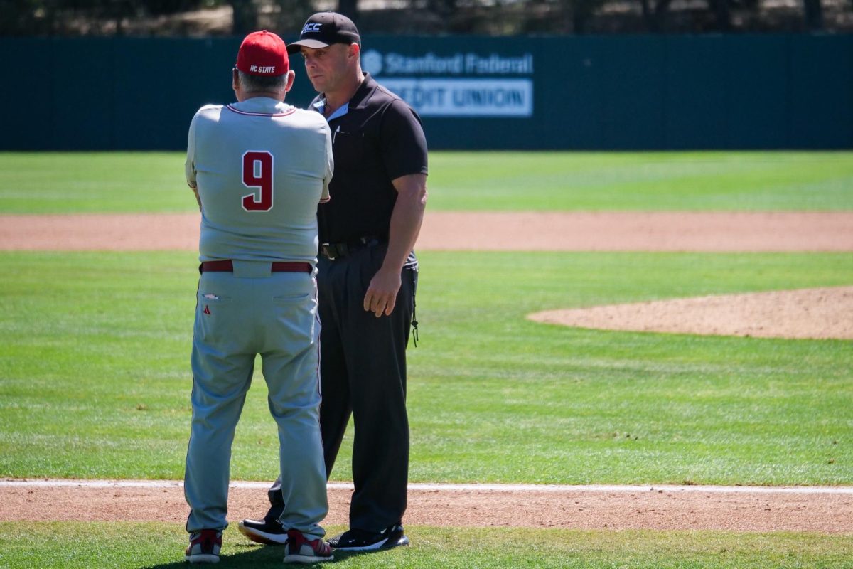 Head Coach Elliot Avent consults with the umpire following a contraversial call during the game against Stanford at Klein Field at Sunken Diamond on Sunday, May 10, 2026. The Cardinal defeated the Wolfpack by a score of 9-5.