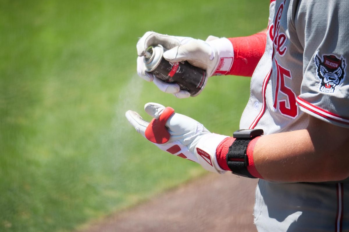 Redshirt junior catcher Drew Lanphere sprays batting spray on his gloves while on-deck during the game against Stanford at Klein Field at Sunken Diamond on Sunday, May 10, 2026. The Cardinal defeated the Wolfpack by a score of 9-5.