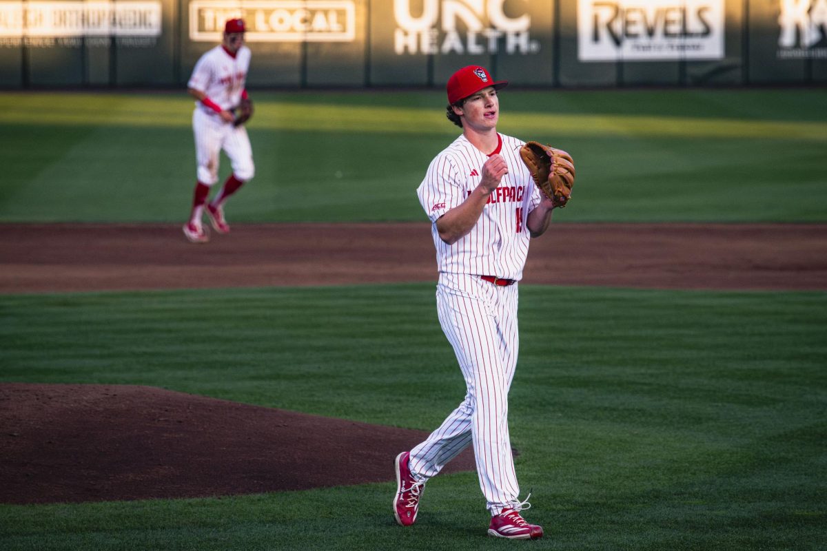 Junior right-handed pitcher Heath Andrews walks off the mound and pats his glove during the game against UNC in Doak Field at Dail Park on Thursday, May 14, 2026. Andrews struck out a career-high 10 batters. The Tar Heels defeated the Wolfpack 9-4.