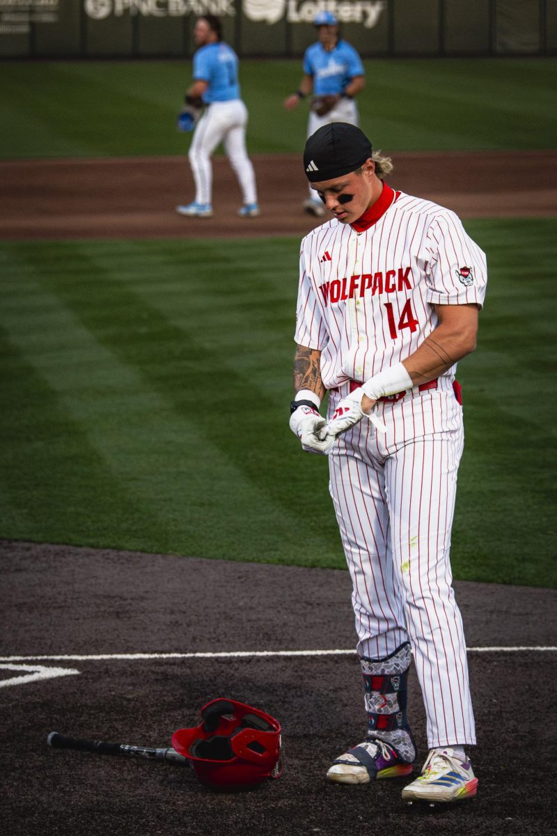 Sophomore outfielder Ty Head takes off his batting gloves during the game against UNC in Doak Field at Dail Park on Thursday, May 14, 2026. The Tar Heels defeated the Wolfpack 9-4.