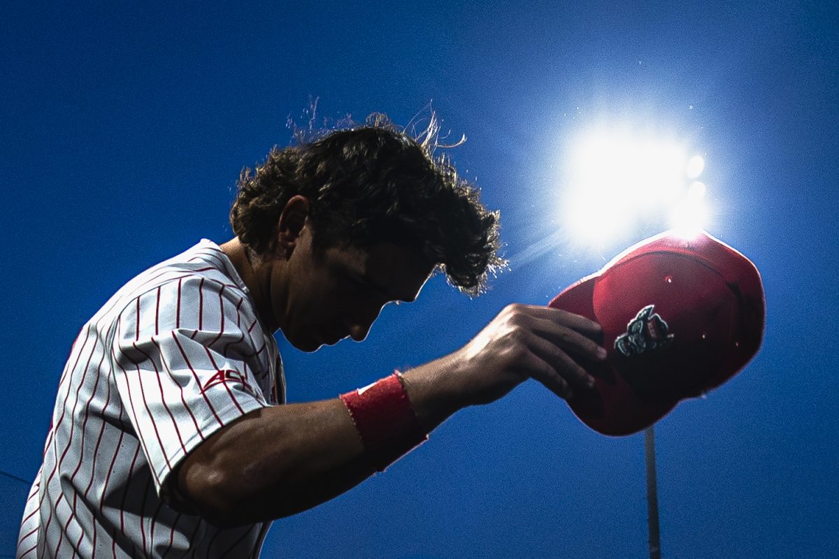 Junior infielder Chris McHugh takes off his hat in the dugout during the game against UNC in Doak Field at Dail Park on Thursday, May 14, 2026. The Tar Heels defeated the Wolfpack 9-4.