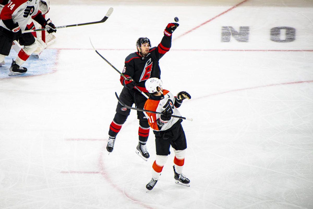 Hurricanes defenseman Sean Walker reaches up to grab the puck during Game Two of the Eastern Conference Semifinals between the Carolina Hurricanes and Philadelphia Flyers in the Lenovo Center on Monday, May 4, 2026. The Hurricanes defeated the Flyers 3-2 in overtime.